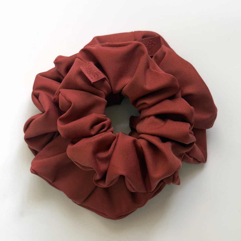 One Large and one mini hair scrunchies in  rust red color, photographed from above on a clean white background.